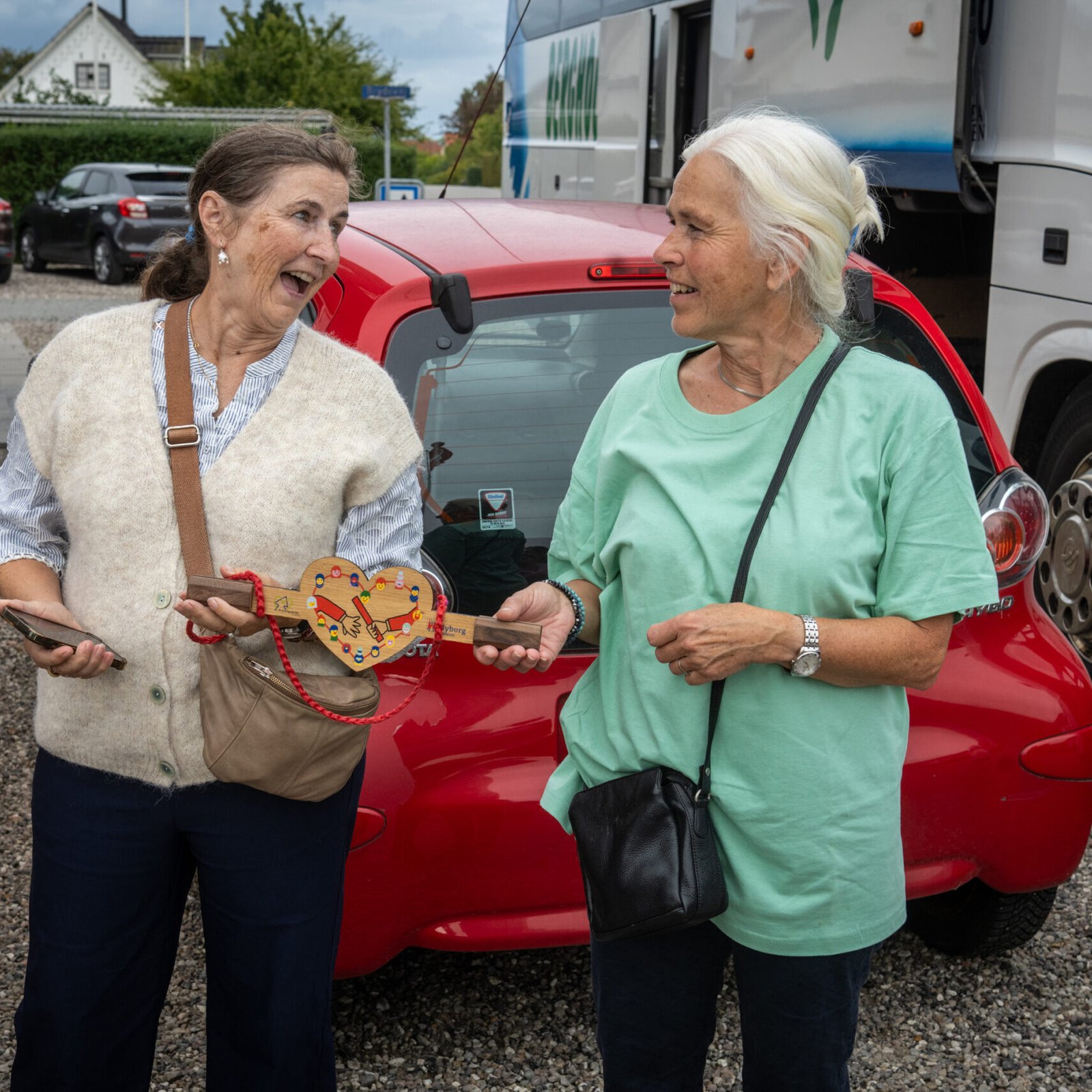 Anne Kirstine Knudsen fra Landsbyrådet tager imod depechen, der ankom med bus. Fællesskabsstafetten i Tårup 12. september 2026.
