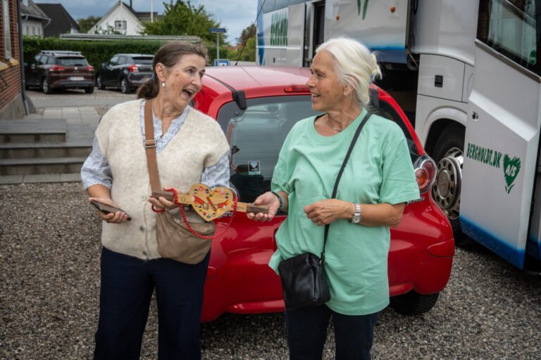 Anne Kirstine Knudsen fra Landsbyrådet tager imod depechen, der ankom med bus. Fællesskabsstafetten i Tårup 12. september 2026.